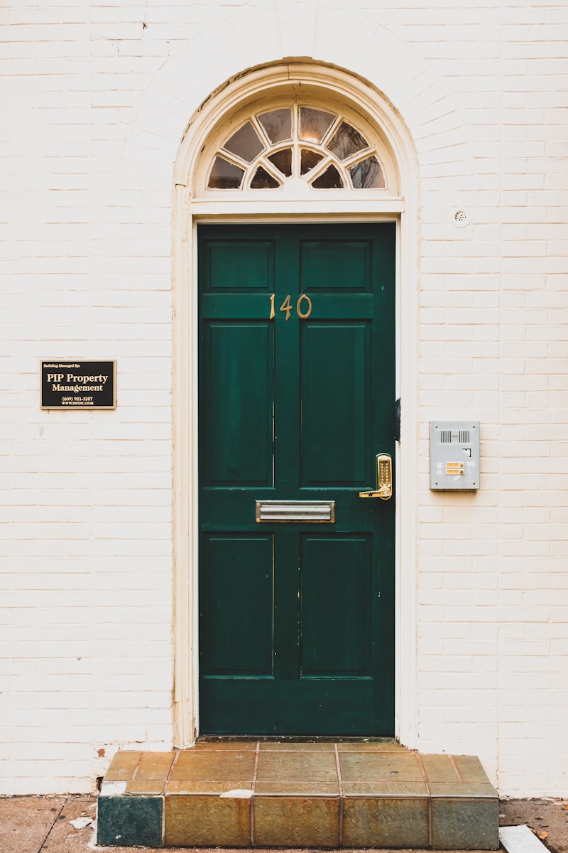 Porte d'immeuble verte avec interphone